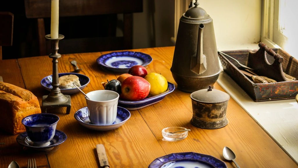 A sunlit farmhouse kitchen table with sourdough, tomatoes, and linen